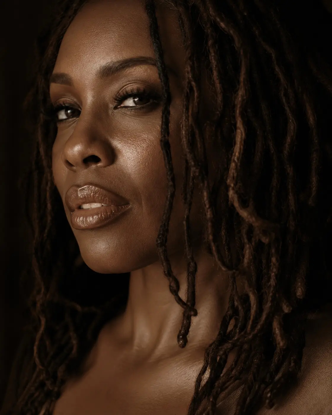 Warm editorial portrait of a Black woman with locs
